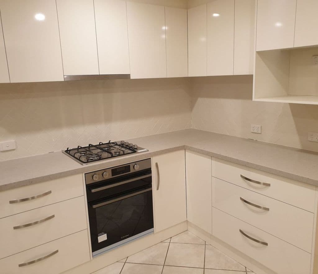Kitchen renovation with a herringbone pattern tiled splashback behind a gas cooktop